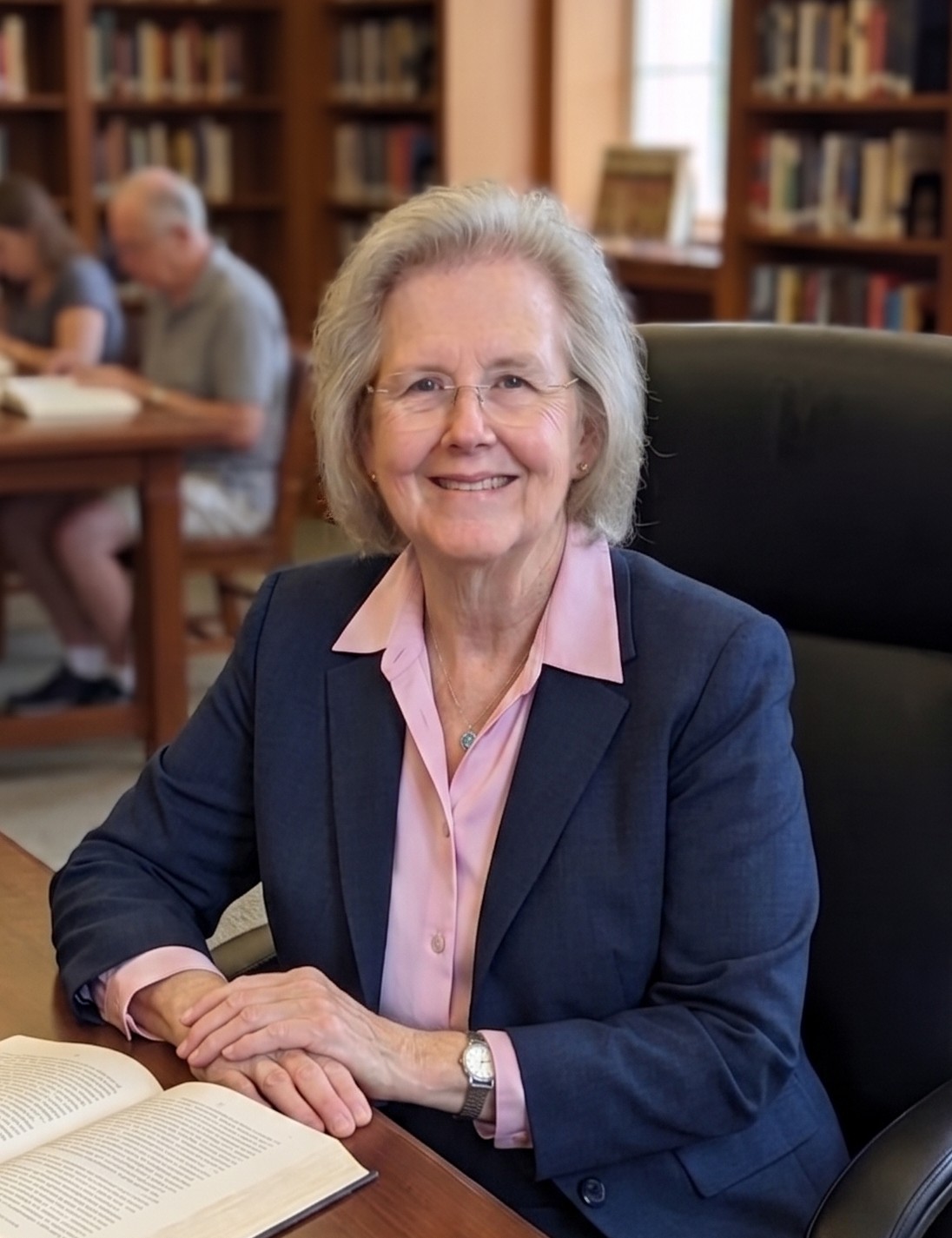 Rev. Beth Head seated at a desk with an open book